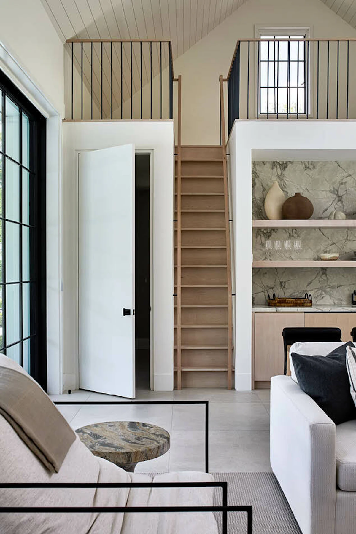 The pool house interior features built-in cabinetry and a narrow staircase to a loft area.