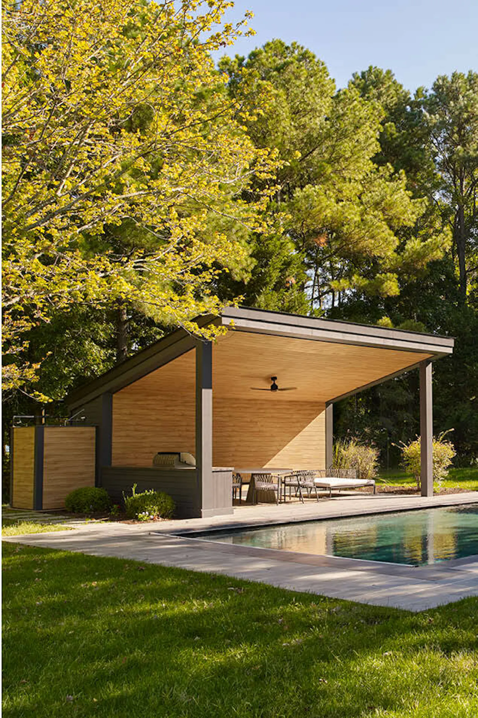 A view of the landscaped exterior, featuring a pool and a pool pavilion