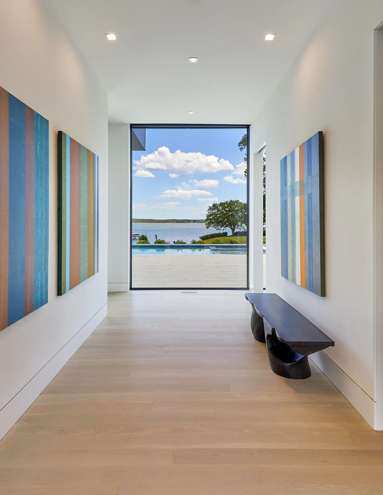 An entry foyer serves as a gallery for the owners art, while an interior staircase leads to second-floor bedrooms. 