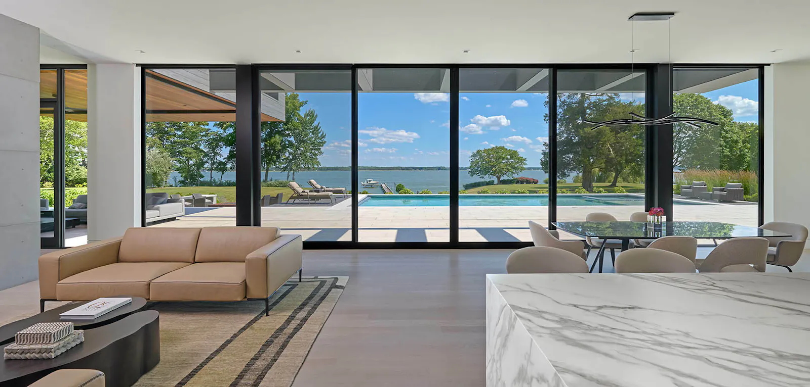 Floor-to-ceiling windows offer clear views of the pool and river. 