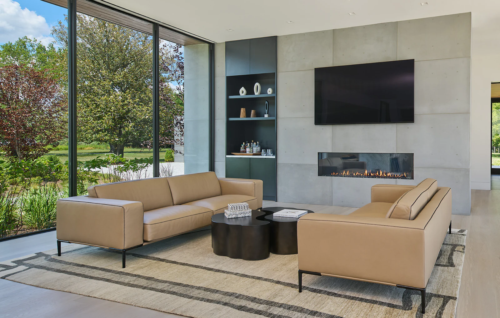 A light-filled dining room and living room include a concrete panel-wrapped fireplace. 