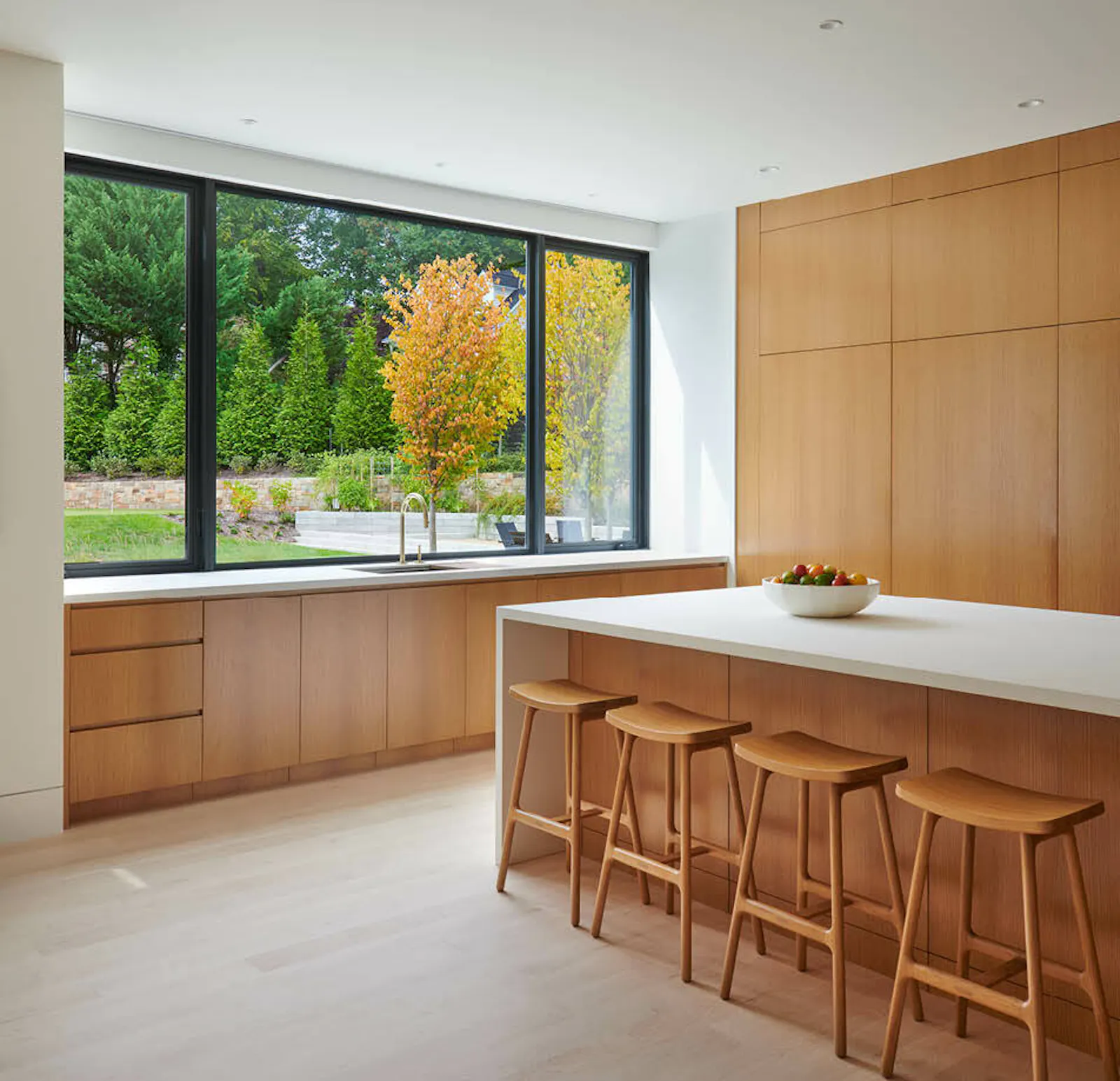 The kitchen features extensive maple cabinetry, hidden storage, and vast views to the outdoors. 