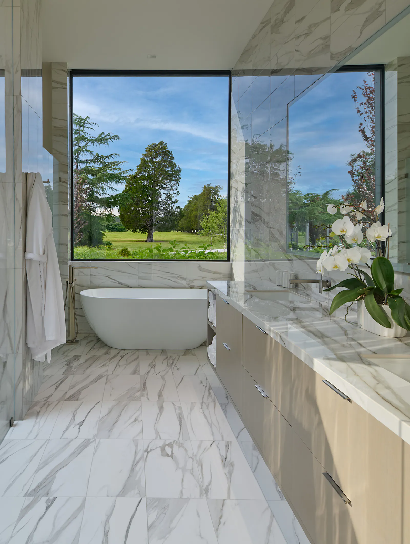 A luxurious stone-wrapped main bathroom includes a walk-out to an outdoor shower. 