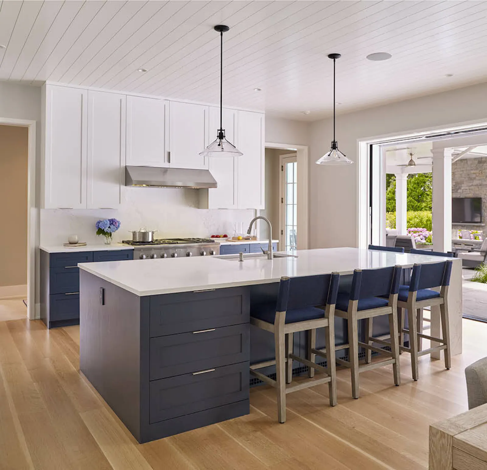 The kitchen includes a walk-out to an outdoor living room with a fireplace and ceiling fan. 