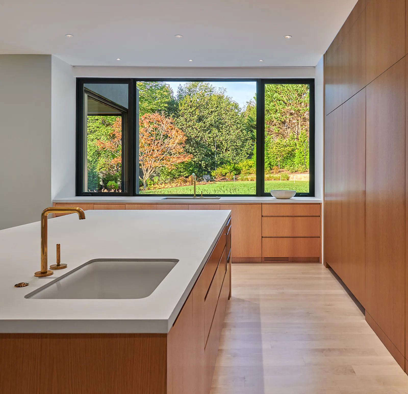 The kitchen features extensive maple cabinetry, hidden storage, and vast views to the outdoors. 