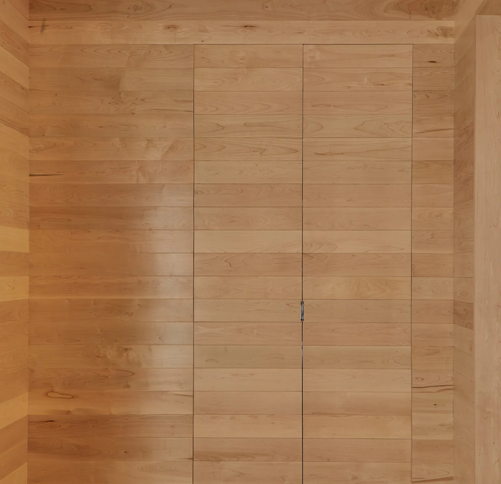 Doorways are integrated into the maple, maintaining visual calm. 