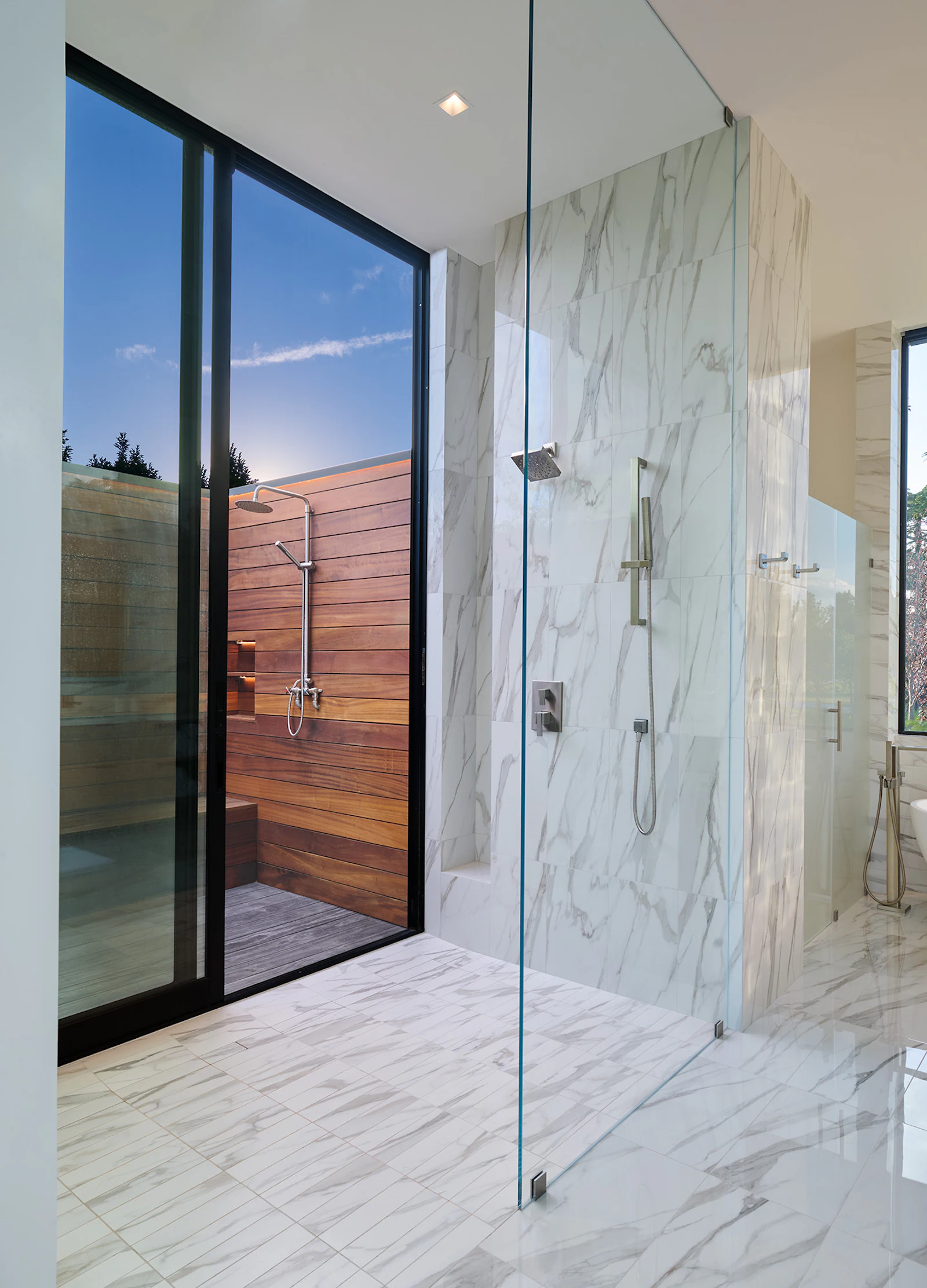 A luxurious stone-wrapped main bathroom includes a walk-out to an outdoor shower. 
