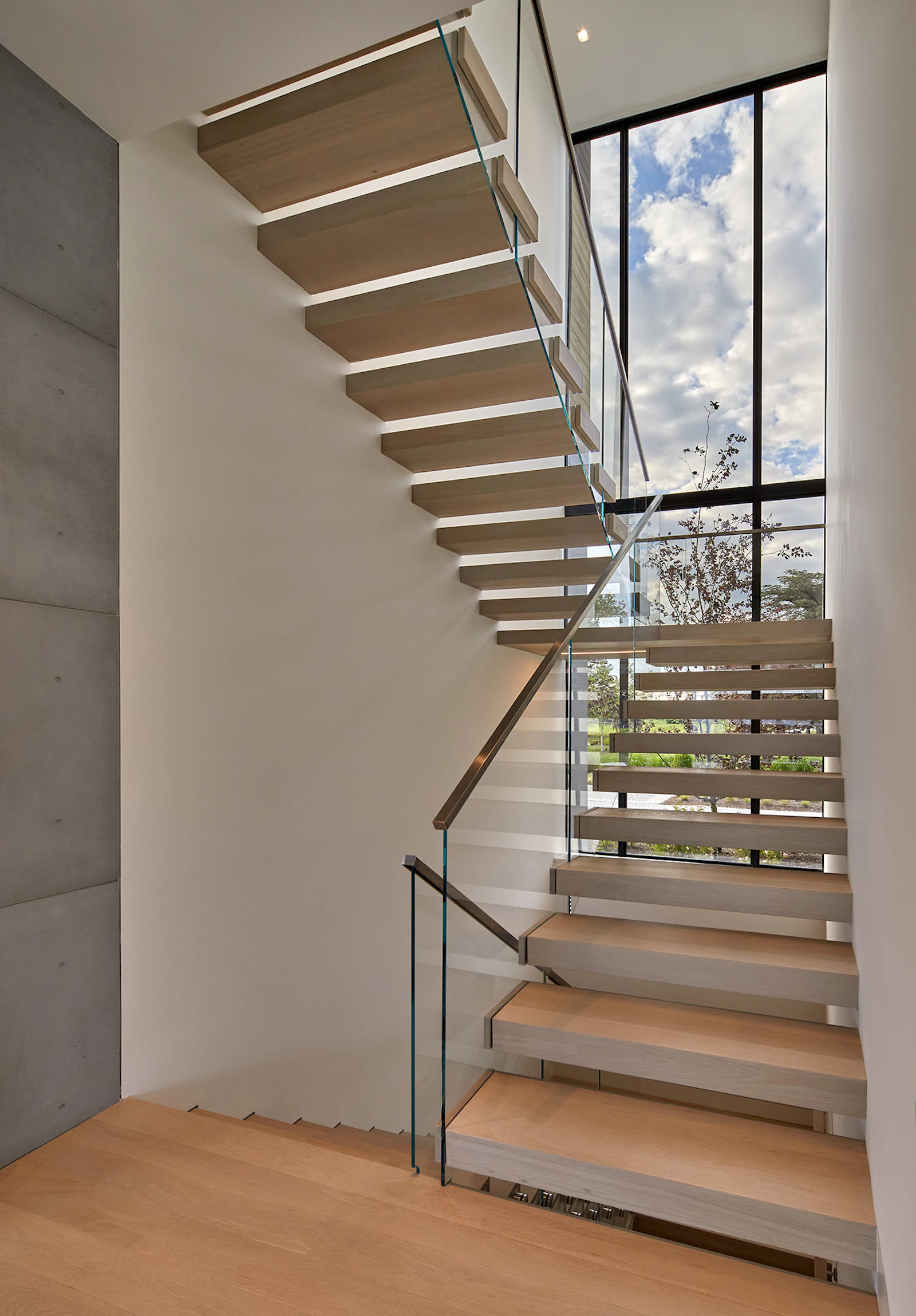 An entry foyer serves as a gallery for the owner's art, while framing views of the river. A staircase leads to additional bedrooms and bathrooms upstairs. 
