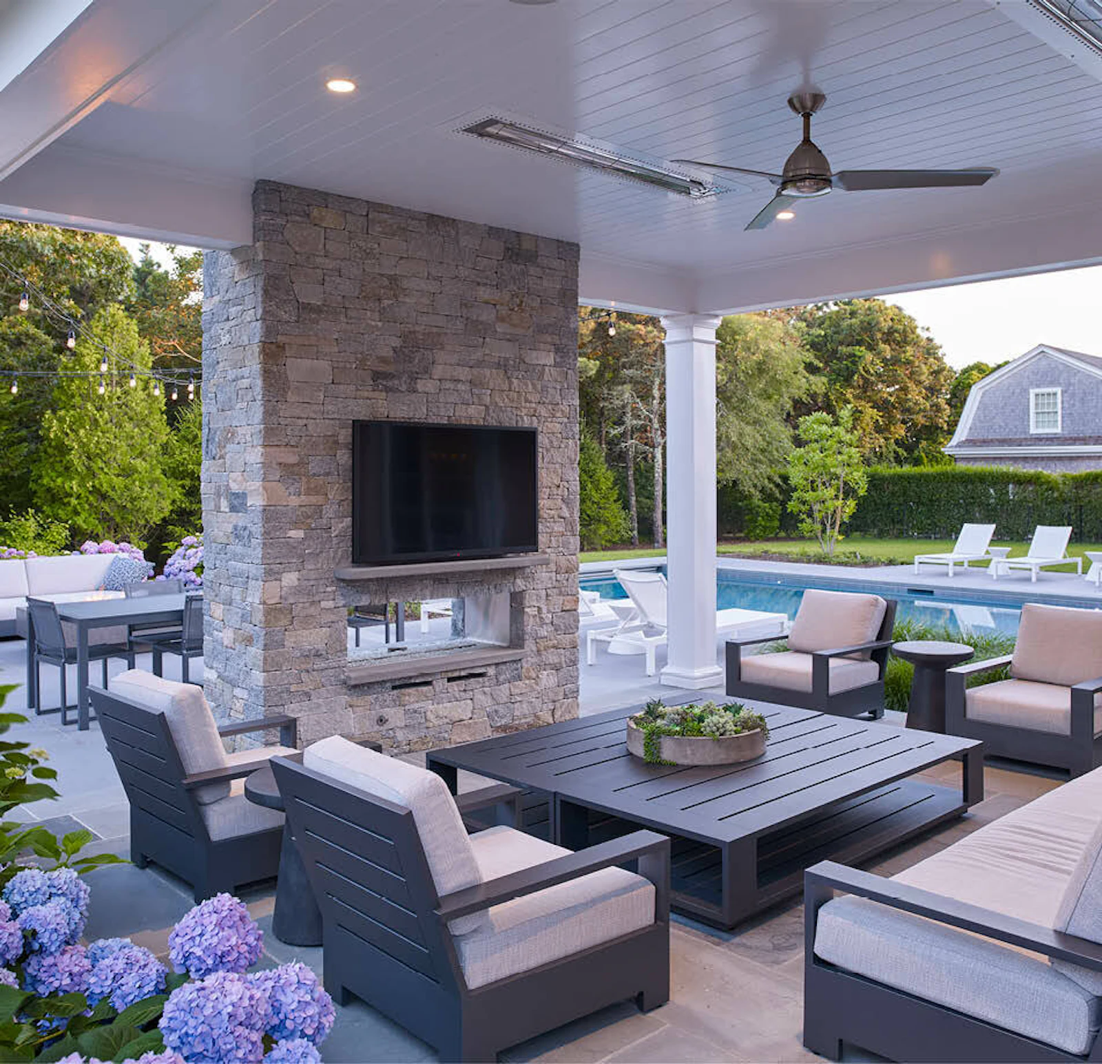 The kitchen includes a walk-out to an outdoor living room with a fireplace and ceiling fan. 