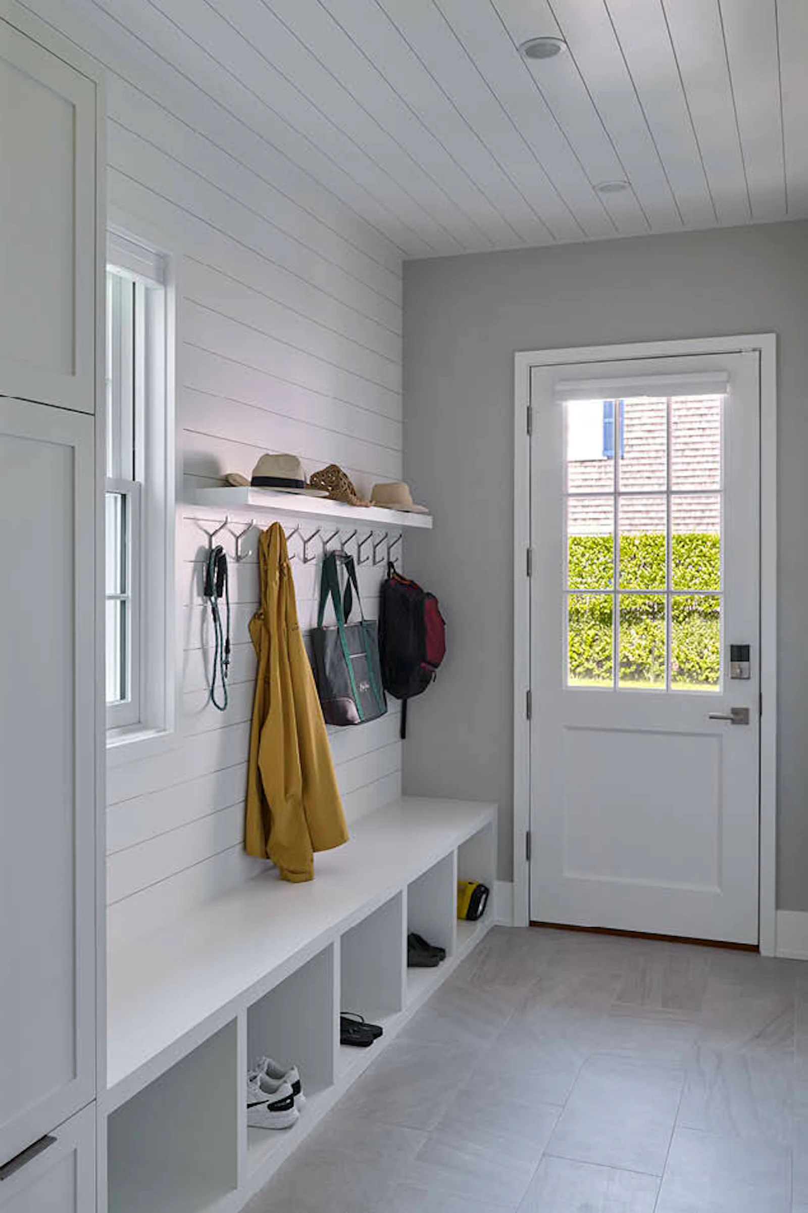 The home centers stunning views to the outdoors and a small mudroom with built-in shelving and cabinetry. 